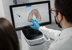 Dentist pointing to a virtual denture model