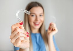 Woman holding Invisalign aligners in Harrisonburg