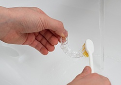 Patient cleaning clear aligner with toothbrush
