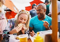 Friends smiling while eating lunch outside