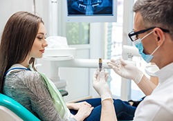 A dentist explaining dental implant treatment to a patient