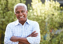 Senior man with patterned shirt standing outside smiling