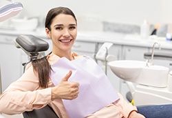 Happy dental patient making thumbs-up gesture