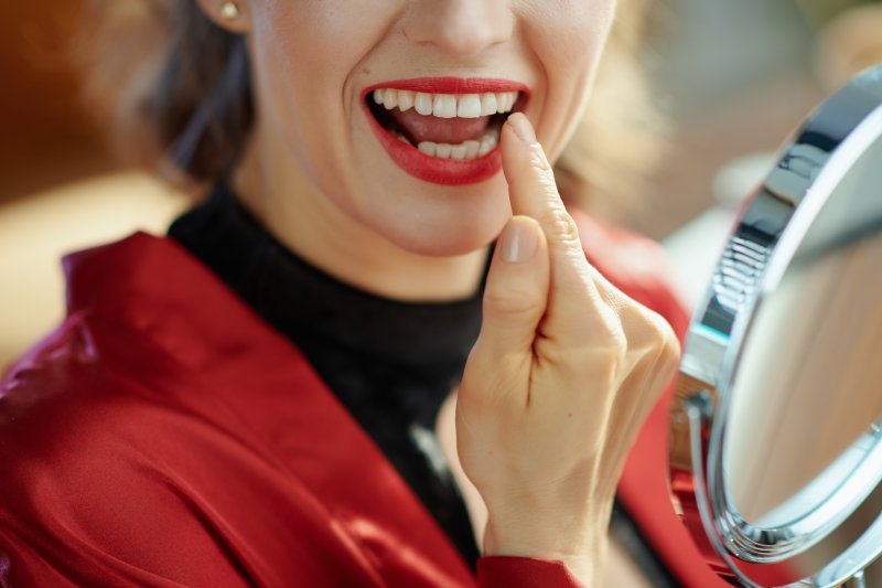 Patient smiling in the mirror after cosmetic dentistry